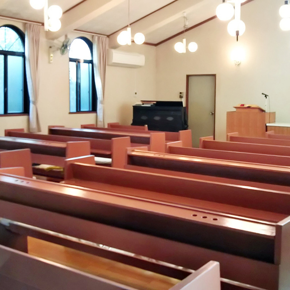 羽生栄光教会の礼拝堂です。中は傾斜の付いた天井で、伝統的な木製ベンチが千ゼインと並んでいます。最奥に牧師が説教を行うための講壇（こうだん）が見えます。