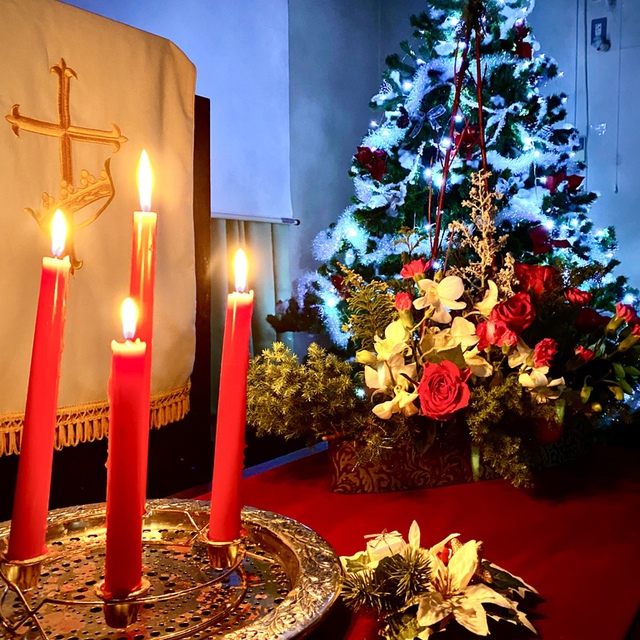 クリスマスイブ・キャンドル礼拝の後のキャンドルと花とクリスマスツリーです。