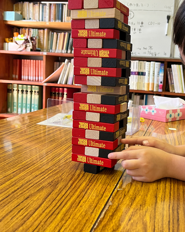 Guchiさんの この一枚「5月最後の礼拝のあと子供たちは「Jenga」でワクワク、ドキドキの時間を過ごしていました。意地悪な？お兄さん、お姉さんたちは一番下のパーツから抜いていきます。今にも倒れそうな塔に困っている小さい子たちを見ながら、マタイ16:15-16のみ言葉が浮かんできました。<br>「あなたは幸いだ。あなたにこのことを現したのは、人間ではなく、わたしの天の父なのだ。わたしも言っておく。あなたはペトロ。わたしはこの岩の上にわたしの教会を建てる。陰府の力もこれに対抗できない」。<br>いろんなことがこれからあると思うけど、確かな岩である主イエスを土台にして、みんながたくましく成長していくことを祈り続けますね。」