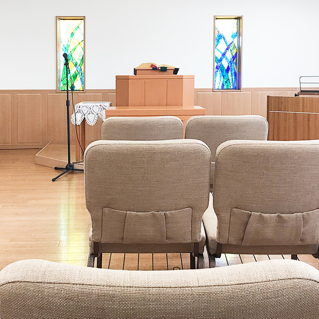 西谷教会の座席は全席自由。お好きな席にお座りください。写真は正面中央の席に座ったところ。前列の椅子に専用のポケットが用意されていますので聖書や讃美歌を収納することが可能です。