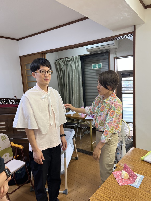 古口さんの この一枚「クリスマスまで、あと約3カ月。準備が始まっています。大人用ケープの採寸のための試着です。え？大人にもあるの！」