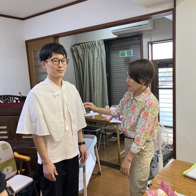 クリスマスまで、あと約3カ月。準備が始まっています。大人用ケープの採寸のための試着です。え？大人にもあるの！