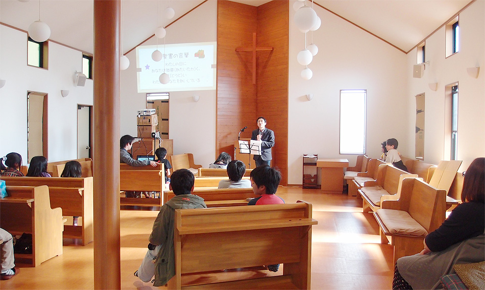 日曜学校で子どもたちに神様のお話を伝える牧師の写真